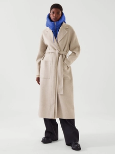 Détail du manteau en laine beige avoine avec revers larges et ceinture à la taille