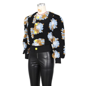 Detail of vintage knit cardigan featuring 3D floral textures and yellow contrast buttons
