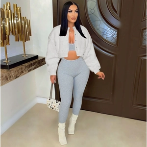 Detail of a white faux fur jacket paired with a grey ribbed top and matching pants