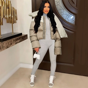 Detail of a chic khaki and beige cropped puffer jacket paired with a sleek grey bodysuit