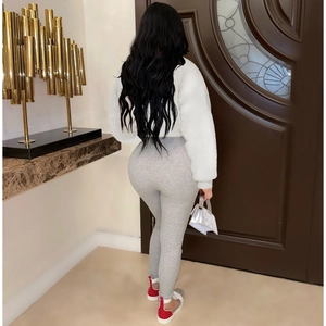 Back view of a white faux fur jacket paired with grey ribbed leggings and sneakers