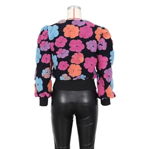 Close-up of the 3D floral texture and black ribbed hem on this vintage style jacket