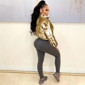 Detail of metallic gold cropped puffer jacket with stand-up collar and ribbed leggings