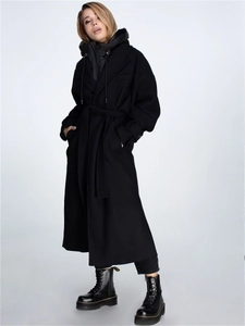 Détail d'un long manteau en laine noir avec gilet à capuche et ceinture à la taille