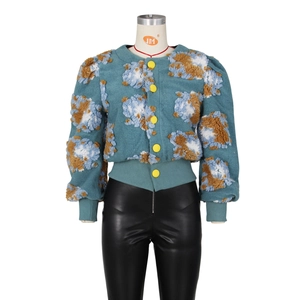 Detailed view of 3D floral texture and yellow buttons on the blue short jacket