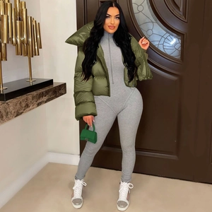 Detail of olive green shiny puffer jacket and grey ribbed bodysuit with zipper collar