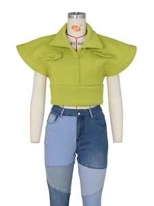 Women's neon green flutter sleeve top with high neck and patchwork denim jeans