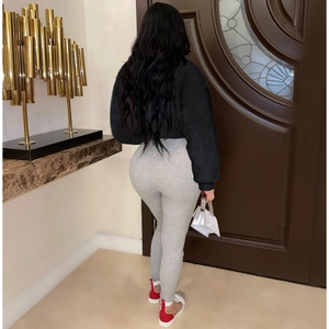 Rear view of woman in black long sleeve crop top and grey ribbed knit leggings set