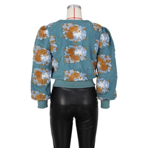 Detailed back view of cropped teal fleece sweatshirt with orange and white floral patterns