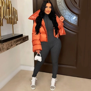 Detail of orange puffer jacket styled with a grey ribbed jumpsuit and mini handbag