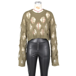 Detail of army green hollow-out distressed knit sweater with black faux leather trousers