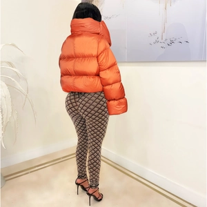 Rear view of a shiny orange quilted puffer jacket and checkered high-waist trousers