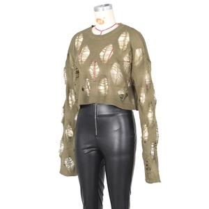 Detail of olive green distressed knit top with large hollow cutouts on mannequin