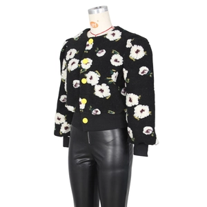 Detailed close-up of textured fabric with 3D floral applique and yellow buttons