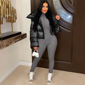 Close-up of black glossy padded jacket paired with grey ribbed knit jumpsuit
