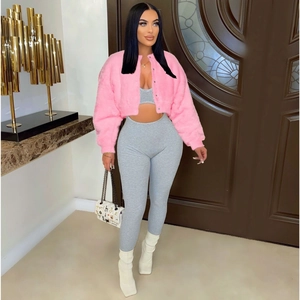 Detail of pink faux fur jacket paired with a gray ribbed knit set and white handbag
