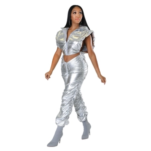 Detail of silver metallic reflective crop vest and pleated trousers with futuristic sheen