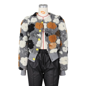 Detail of sherpa jacket featuring grey base with black and orange floral patterns