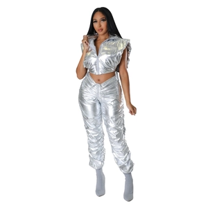 Detail of silver metallic puffer vest and matching trousers with high-waisted design