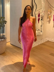Dettaglio dell'abito allacciato al collo rosa acceso con frange e trama a pieghe