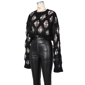 Detailed view of black cropped knit sweater with distressed cut-outs and leather pants