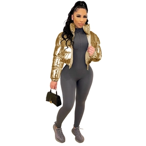 Detail view of shiny golden metallic puffer jacket and grey ribbed bodysuit for women