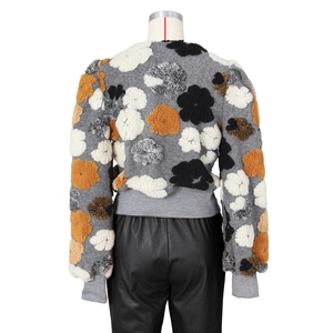 Detail view of vintage floral applique cardigan and black faux leather pants for women