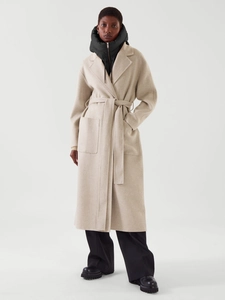 Détail du manteau long en laine beige avec ceinture et faux col à capuche noir