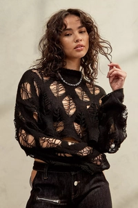 Close-up of distressed black knit sweater with punk style hollow-out details and chain