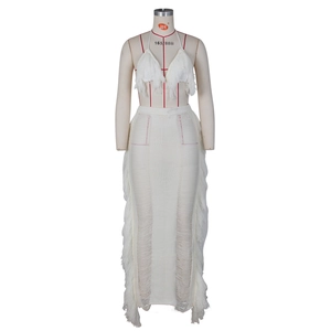 Detail of white crochet knit two-piece set featuring dense fringe trim on the skirt edges
