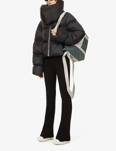 Detail of black puffer jacket showing high neck scarf collar and zipper texture