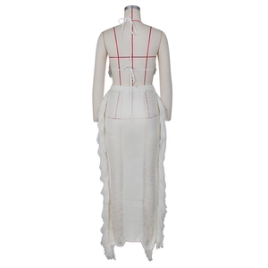 Close-up of white knitted halter top and floor-length skirt with long fringe details