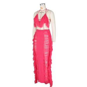 Detailed close-up of fuchsia knit two-piece set with long fringe and side cut-outs
