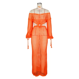 Détail de robe longue orange au crochet avec découpe à la taille, anneau et glands aux manches