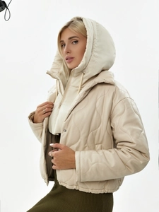 Détail du gilet à capuche beige en similicuir avec motif matelassé vagues