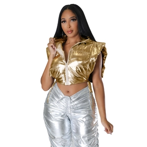 Detail of metallic gold hooded puffer vest and silver ruched high-waist pants on model