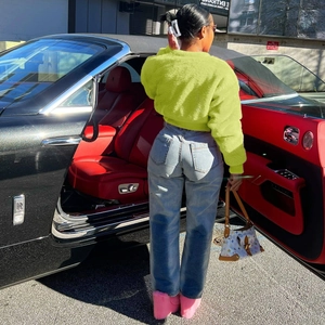 Rear view of vibrant neon green faux fur short jacket and high waist jeans outfit