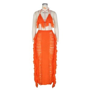 Detail of orange knitted two-piece beach set featuring long fringe trim and halter neck design