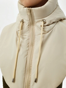 Détail du faux col beige matelassé à capuche avec fermeture éclair et cordon de serrage