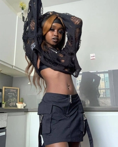 Detail view of black cropped knit top with distressed cut-outs and cargo skirt