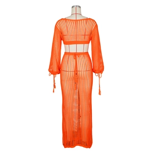 Détails de la robe en crochet orange ajouré avec finitions à pompons et perles