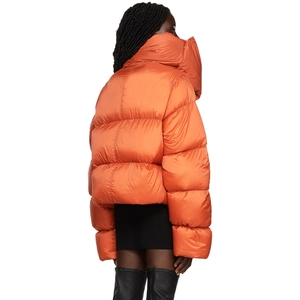 Macro view of oversized orange puffer jacket featuring a high collar and quilted texture