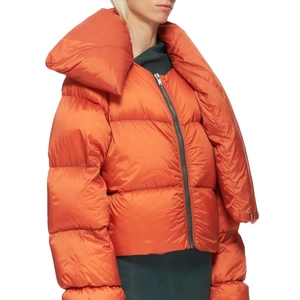 Detail of bright orange puffer jacket featuring an oversized shawl collar and quilted fabric