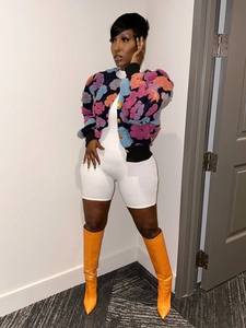 Detailed view of women floral knit cardigan paired with vibrant orange crocodile boots