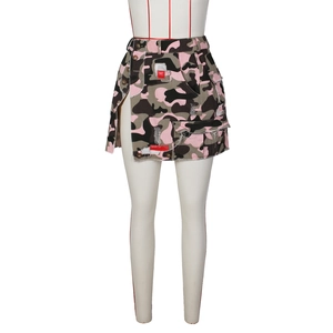 Détail de la mini-jupe camouflage rose avec fentes boutonnées et patchs rouges