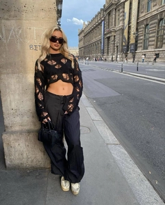 Detail of trendy black hollow out knit crop top with long sleeves in street style fashion