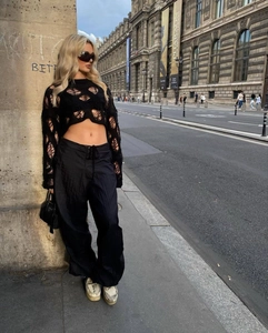 Detail of black distressed hollow out knit crop top sweater in a street style look