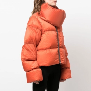 Detailed side view of bright orange oversized quilted jacket with high stand collar