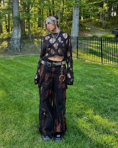 Close-up of grunge style hollow out knit sweater paired with tie-dye cargo pants