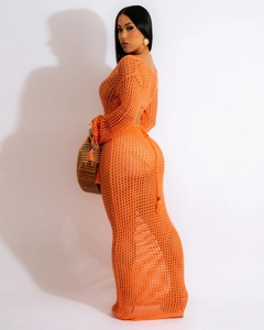 Détail d'une robe maxi en crochet orange vif avec manches longues et maille ajourée